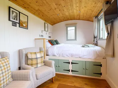 a bedroom with a bed and a chair in a room at Charollais in Oswestry