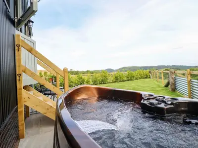 a hot tub on the balcony of a house at Charollais in Oswestry