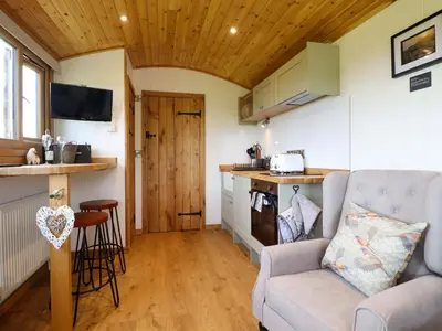 a living room with a couch and a kitchen at Defaid Cymreig in Oswestry
