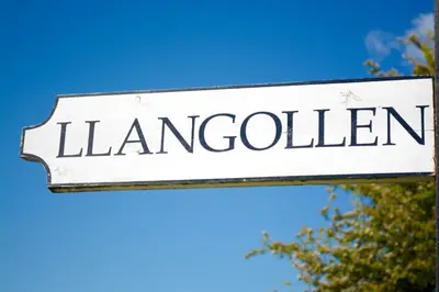 a white sign that reads lancivil istg at Llangollen High Street 4 bedrooms Sleeps 12 in Llangollen