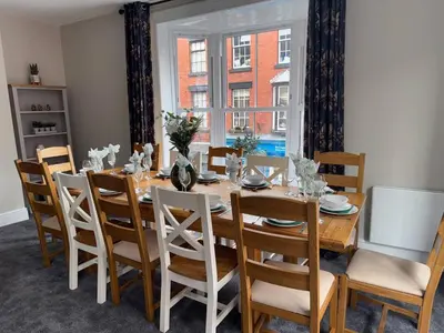 a dining room with a wooden table and chairs at Llangollen High Street 4 bedrooms Sleeps 12 in Llangollen