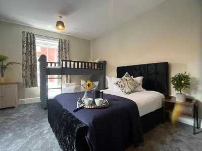 a bedroom with a bunk bed with a blue blanket at Llangollen High Street 4 bedrooms Sleeps 12 in Llangollen