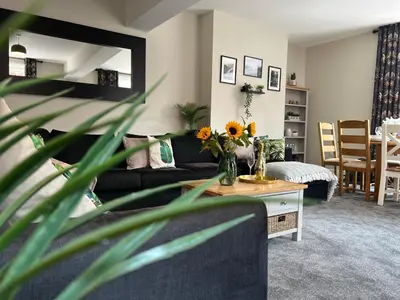 a living room with a couch and a table with flowers at Llangollen High Street 4 bedrooms Sleeps 12 in Llangollen