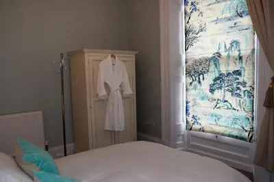 a bedroom with a white robe hanging on a cabinet at Awel Mor 3 Luxury Apartment in Aberystwyth
