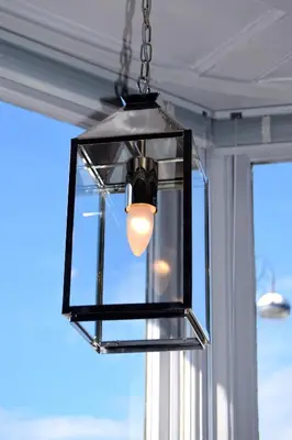 aendant light hanging from a ceiling with a window at Awel Mor 3 Luxury Apartment in Aberystwyth