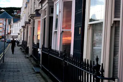 a person walking down a street next to buildings at Awel Mor 3 Luxury Apartment in Aberystwyth