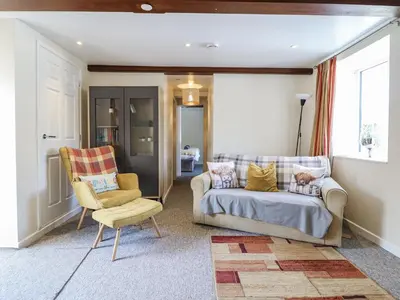 a living room with a couch and a chair at 1 Y Llew in Llandinam