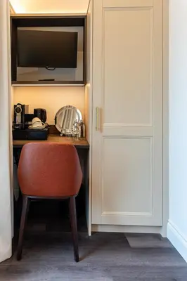 a room with a desk with a chair and a television at Ty Glyn Hotel in Ciliau-Aeron
