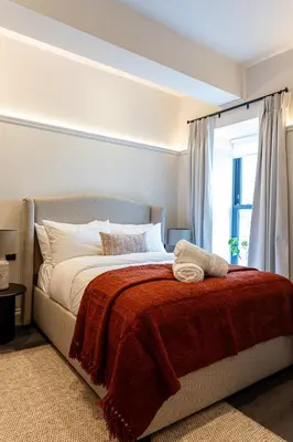 a bedroom with a bed with a red blanket and a window at Ty Glyn Hotel in Ciliau-Aeron