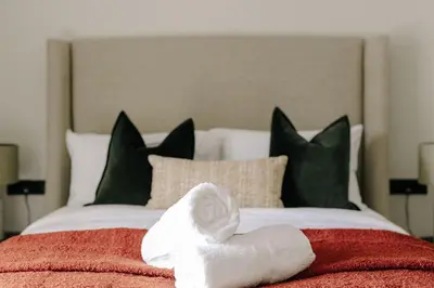 a bed with two folded towels on top of it at Ty Glyn Hotel in Ciliau-Aeron