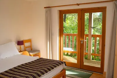a bedroom with a bed and a sliding glass door at Owls Roost Eco Lodge Apartment Lampeter in Lampeter