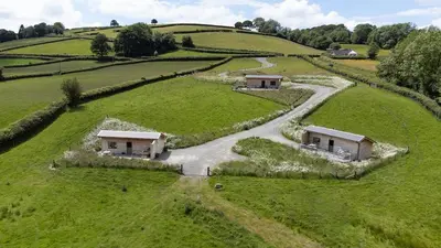 an aerial view of a house in a field at Birch Banc Retreats - Bedw Cabin