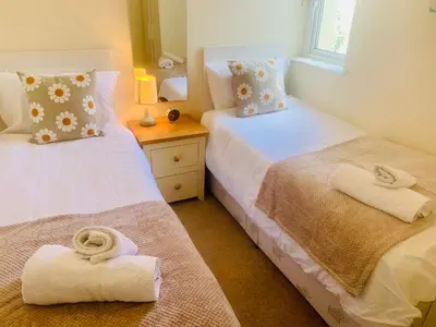two beds in a room with towels on them at 3 Riverside Bungalows in Llanbedr