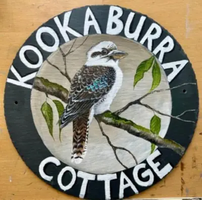 a sign with a bird sitting on a tree branch at Kookaburra Cottage in Brecon