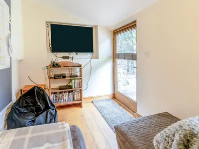 a living room with a flat screen tv on the wall at Wern Farm Barn in Cwmdu
