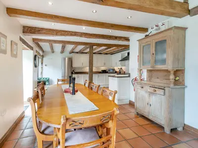 a large kitchen with a wooden table and chairs at Wern Farm Barn in Cwmdu