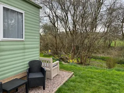 a green house with two chairs and a bench at Sylvan in Builth Wells