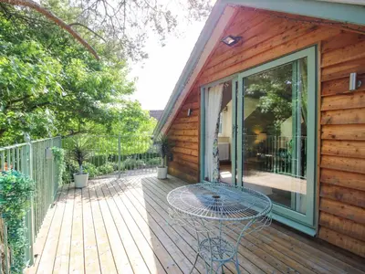 a deck with a glass table on a house at The Hideaway in Shrewsbury