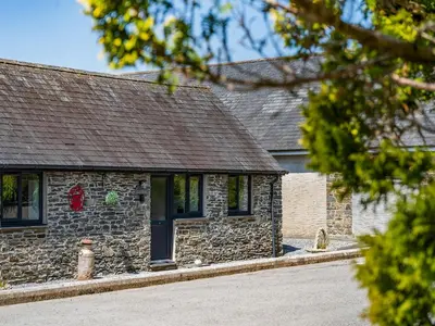a stone building with a red wreath on it at The Old Cowsheds 5 - Llanilar - Uk49790 in Cribyn