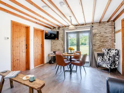 a living room with a table and chairs at The Old Cowsheds 5 - Llanilar - Uk49790 in Cribyn