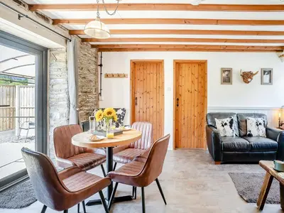a living room with a table and chairs and a couch at The Old Cowsheds 5 - Llanilar - Uk49790 in Cribyn