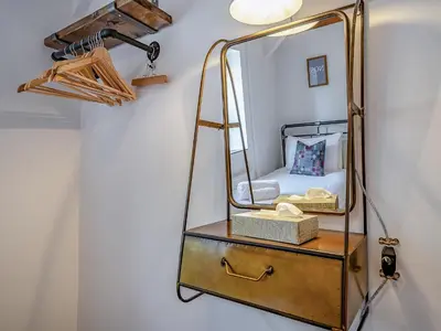 a mirror on a dresser next to a wall at The Old Cowsheds 4 - Daniel Ddu - Uk49789 in Cribyn