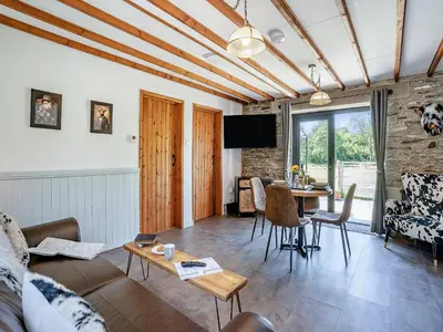 a living room with a couch and a table at The Old Cowsheds 4 - Daniel Ddu - Uk49789 in Cribyn
