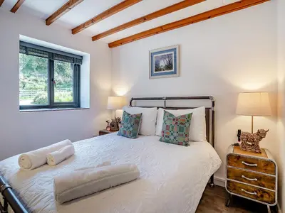 a bedroom with a large bed with two pillows at The Old Cowsheds 4 - Daniel Ddu - Uk49789 in Cribyn