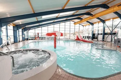 a large swimming pool with a hot tub in a building at 6 Birth Caravan Quay West Sea Views in New Quay