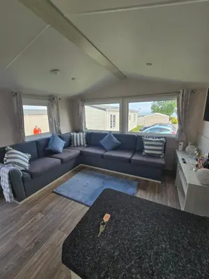 a living room with a couch and a table at 6 Birth Caravan Quay West Sea Views in New Quay