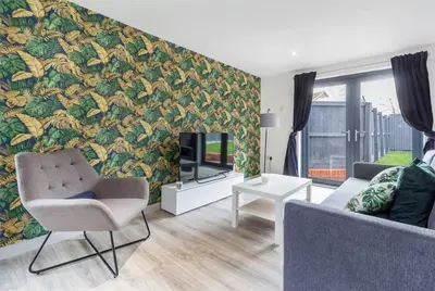 a living room with a couch and a wall mural at Zest Homes 87b Bridge Street in Leominster