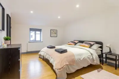 a bedroom with a large bed and a dresser at Zest Homes 87 Bridge Street in Leominster