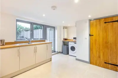 a kitchen with white cabinets and a wooden door at Zest Homes 87 Bridge Street in Leominster