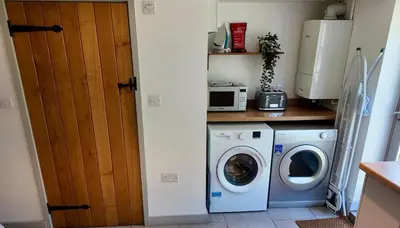 a kitchen with a washing machine and a microwave at Zest Homes 87a Bridge Street in Leominster
