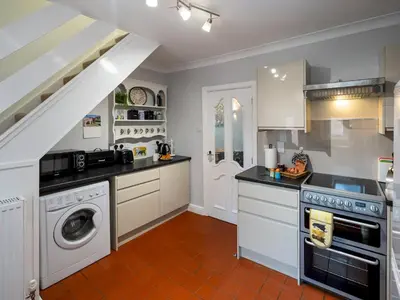 a kitchen with white cabinets and a washer and dryer at Fantastic 3-bed home close to Shrewsbury centre - Pass the Keys in Shrewsbury