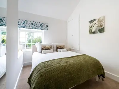 a white bedroom with a bed and a window at Fantastic 3-bed home close to Shrewsbury centre - Pass the Keys in Shrewsbury