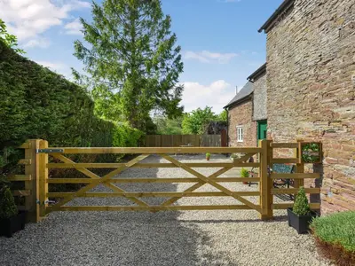 a wooden gate in front of a brick building at Ford Farm in Ludlow
