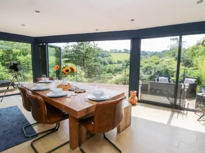 a dining room with a table and a large window at The Old Barn in Lampeter