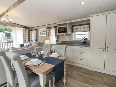 a kitchen and living room with a table and chairs at 34 The Beaumont in New Quay