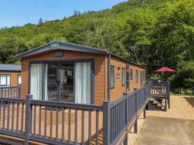 a cabin with a wooden deck with a fence at 34 The Beaumont in New Quay