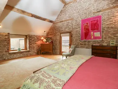 a bedroom with a bed and a brick wall at The Art House in Leominster