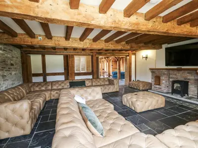 a large living room with a couch and a fireplace at Stud Farm House in Knighton