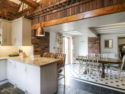 a kitchen and dining room with a table and chairs at Stud Farm House in Knighton