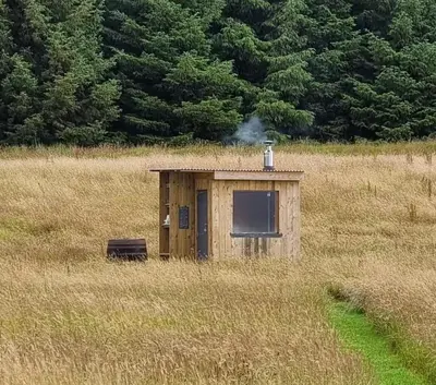a small building in the middle of a field at Glamping Pod - Sleeps 2 - Pets - Parking - Wifi in Llanon