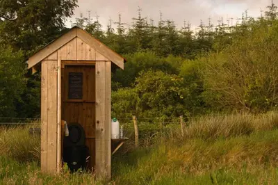 a small wooden out house in the middle of a field at Glamping Pod - Sleeps 2 - Pets - Parking - Wifi in Llanon