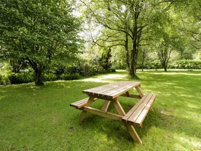 a wooden picnic table sitting in a field of grass at Ty Bedwen in Machynlleth