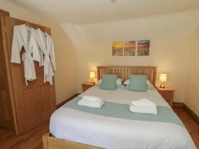 a bedroom with a large bed with towels on the door at Felin Gogoyan in Tregaron