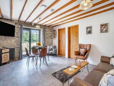 a living room with a couch and a table at The Old Cowsheds 3 - Mynach - Uk49788 in Cribyn