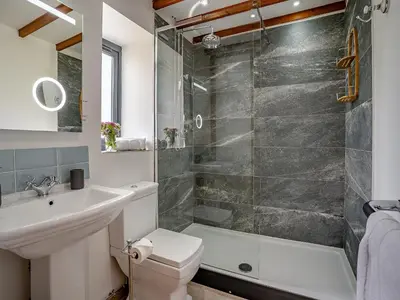 a bathroom with a shower and a toilet and a sink at The Old Cowsheds 3 - Mynach - Uk49788 in Cribyn
