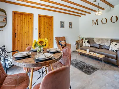 a living room with a wooden table and chairs at The Old Cowsheds 3 - Mynach - Uk49788 in Cribyn